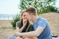 Young couple sitting on beach and feeding each other Royalty Free Stock Photo