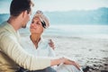 Young couple sitting on the beach, hugging and looking at each other with love Royalty Free Stock Photo
