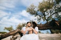 Young couple sitting on the beach near an old tree. Love concept Royalty Free Stock Photo