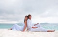 Young couple sitting on the beach near the seaside Royalty Free Stock Photo