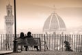 Young couple sitting on a bench, in front of Florence cityscape panorama