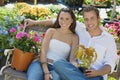 Young couple sitting on bench in garden Royalty Free Stock Photo