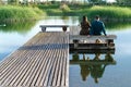 young couple sitting on a bench at a lake pontoon Royalty Free Stock Photo