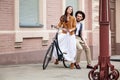 Young couple sitting on a bicycle against the wall