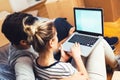 Young couple sitting between boxes, using a laptop Royalty Free Stock Photo