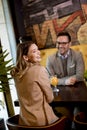 Young couple sitting in the cafe and drinking orange juice Royalty Free Stock Photo