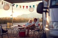 A young couple sitting at the campsite in the nature and chatting. Relationship, vacation, camping, nature Royalty Free Stock Photo