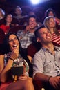 Young couple sitting in cinema smiling Royalty Free Stock Photo