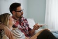 Young couple sitting on couch and watching television Royalty Free Stock Photo