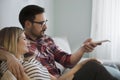 Young couple sitting on couch and watching television Royalty Free Stock Photo