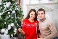 Young couple sitting by Cristmas tree Royalty Free Stock Photo