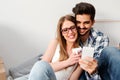 Young couple sitting on the floor of empty apartment looking at smart phone Royalty Free Stock Photo