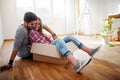 Young couple sitting on the floor of empty apartment. Move in to new home. Royalty Free Stock Photo
