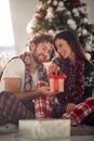 A young couple sitting on the floor enjoying Xmas presents. Christmas, relationship, love, together Royalty Free Stock Photo