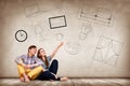 Young couple sitting on the floor among painted furniture on the wall. Royalty Free Stock Photo