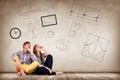 Young couple sitting on the floor among painted furniture on the wall. Royalty Free Stock Photo