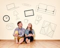 Young couple sitting on the floor among painted furniture on the wall. Royalty Free Stock Photo