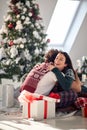 A young couple sitting on the floor surrounded by Xmas presents and hugging. Christmas, relationship, love, together Royalty Free Stock Photo