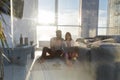 Young Couple Sitting On Floor Using Laptop Tablet Computer Modern Apartment Big Panoramic Window Sea View, Mix Race Man Royalty Free Stock Photo