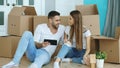 Young couple sitting on floor using tablet computer after reloction in their new home Royalty Free Stock Photo