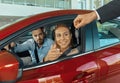 Young couple sitting inside new car and holding keys to it. Concept for car rental Royalty Free Stock Photo