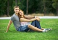 Young couple sitting on the lawn in the park Royalty Free Stock Photo