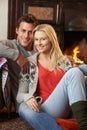 Young couple sitting by open fire Royalty Free Stock Photo