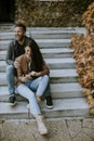 Young couple sitting on outdoor stairs on a autumn day Royalty Free Stock Photo