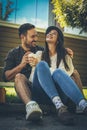 Young couple sitting at park drinking coffee. Spring season. Royalty Free Stock Photo