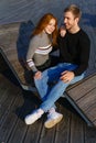 young couple are sitting in the park on a wooden bench hugging Royalty Free Stock Photo
