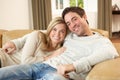 Young couple sitting and relaxing on sofa Royalty Free Stock Photo