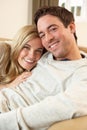 Young couple sitting and relaxing on sofa Royalty Free Stock Photo