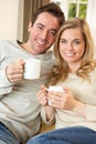 Young couple sitting and relaxing on sofa Royalty Free Stock Photo