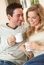 Young couple sitting and relaxing on sofa Royalty Free Stock Photo