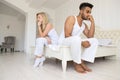 Young Couple Sitting Separate On Bed, Having Conflict Relationships Problem, Sad Negative Emotions Hispanic Man And Royalty Free Stock Photo