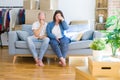 Young couple sitting on the sofa arround cardboard boxes moving to a new house tired rubbing nose and eyes feeling fatigue and Royalty Free Stock Photo