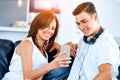 Young couple looking at mobile phone while sitting at home Royalty Free Stock Photo