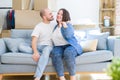 Young couple sitting on the sofa smiling very happy showing keys of new home, moving and buying new apartmet concept Royalty Free Stock Photo