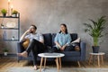 Young Couple Sitting on the Sofa. The Woman Tears Up The Photo. Family Conflict.