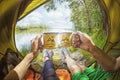 Young couple sitting in the tent and drinking tea while looking on the Desna river