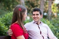 Young couple sitting together on a bench in the park. Royalty Free Stock Photo