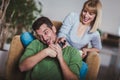 Couple sitting together on a sofa at home watching television, joyfully smiling enjoying a night in together Royalty Free Stock Photo