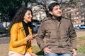 Young couple sitting together and talking on park bench Royalty Free Stock Photo