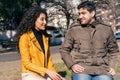 Young couple sitting together and talking on park bench Royalty Free Stock Photo