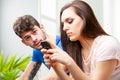 Young couple sitting using a mobile phone with focus to the man Royalty Free Stock Photo