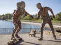 Young couple on skateboard with Basset Hound dog sculpture