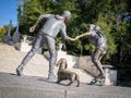 Young couple on skateboard with Basset Hound dog sculpture