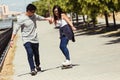 Young couple skateboarding in the street. Royalty Free Stock Photo