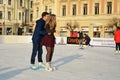 Young couple skating on ice skating rink