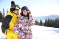 Young couple at ski resort, space for text. Winter vacation Royalty Free Stock Photo